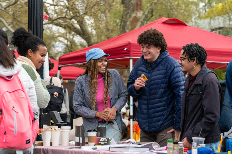 Group of students standing outside at a booth for a campus club