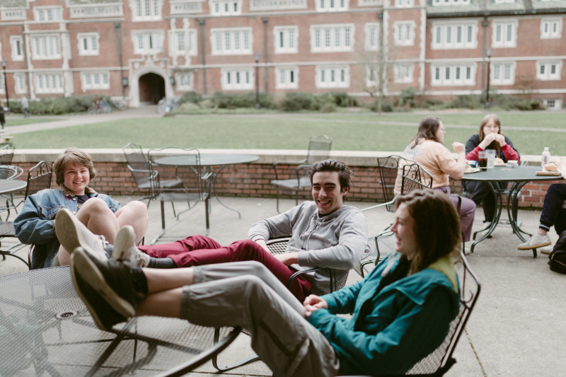 Three students lounging at a table at Reed