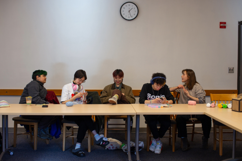 Five students having a conversation at a long table